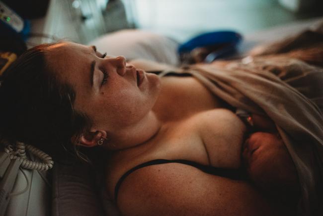 Mother breastfeeding her new baby with Perth birth photographer at the Family Birthing Centre