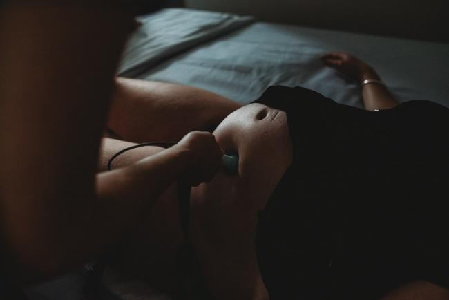 Close up of pregnant woman with a doppler on her tummy with Perth birth photographer at the Family Birthing Centre