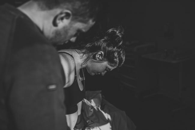 Black and white image of pregnant woman leaning over next to partner with Birth Photographer Perth at SJOG Mt Lawley