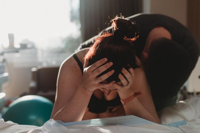 Pregnant woman with hands in her head during labour with Birth Photographer Perth at SJOG Mt Lawley
