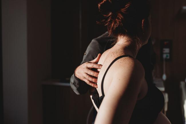 Partner rubbing back of pregnant woman in labour with Birth Photographer Perth at SJOG Mt Lawley