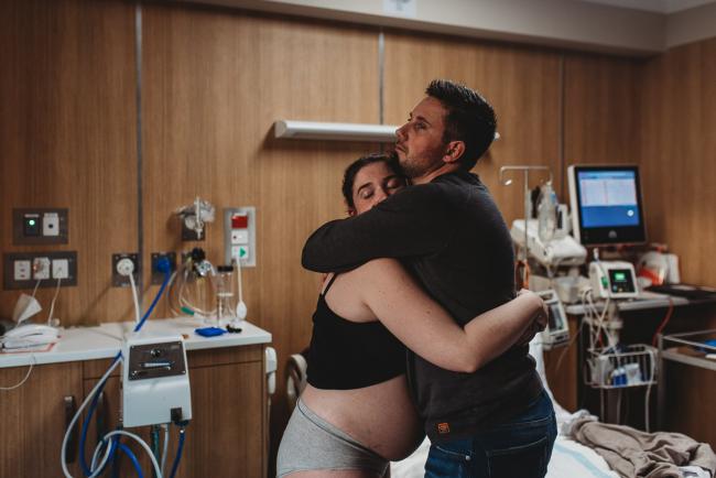 Pregnant woman and partner hugging with Perth Birth Photographer at SJOG Mt Lawley