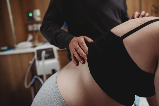 Birth-Photographer-Perth-33-of-60 Man stroking labouring mother's back with Perth Birth Photographer at SJOG Mt Lawley