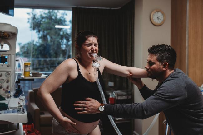 Pregnant woman using gas during contraction with Birth Photographer Perth at SJOG Mt Lawley
