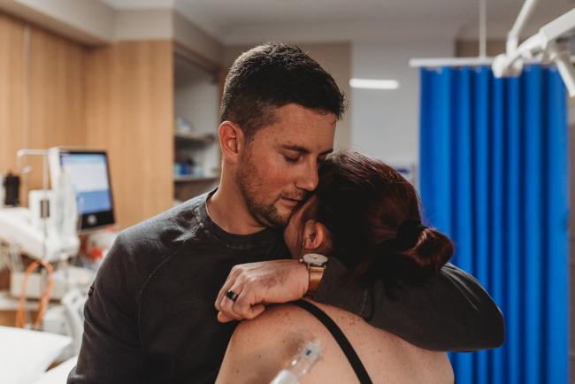 Birth-Photographer-Perth-39-of-60 Man hugging and kissing his labouring partner with Perth Birth Photographer at SJOG Mt Lawley