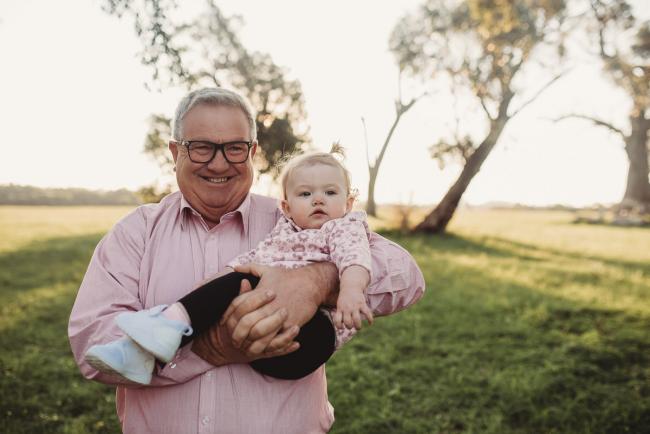 Grandfather holding granddaughter during Perth family photography session at Perry's Paddock during golden hour