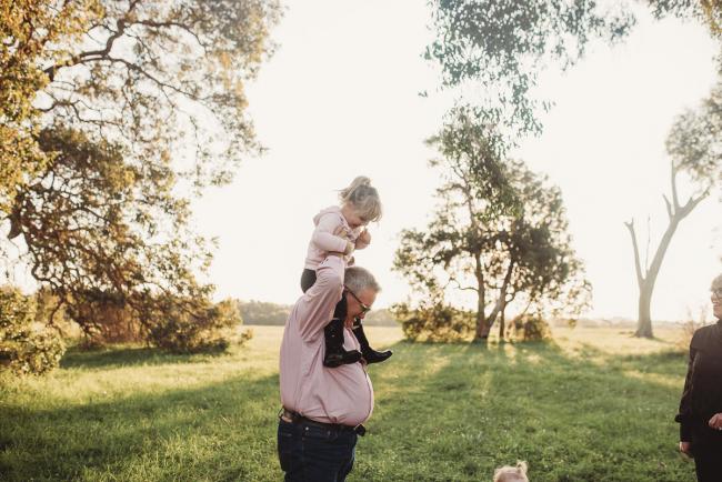 Grandfather with granddaughter on his shoulders during Perth family photography session at Perry's Paddock during golden hour