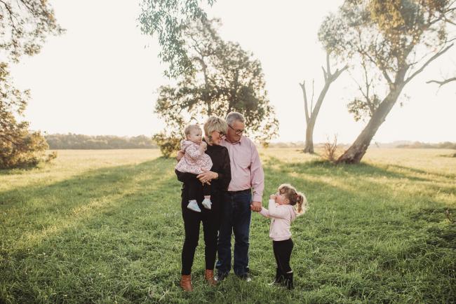 Grandparents holding granddaughters during Perth family photography session at Perry's Paddock during golden hour