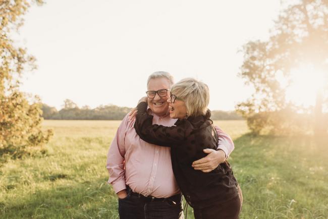 Woman hugging man and laughing during Perth family photography session at Perry's Paddock during golden hour