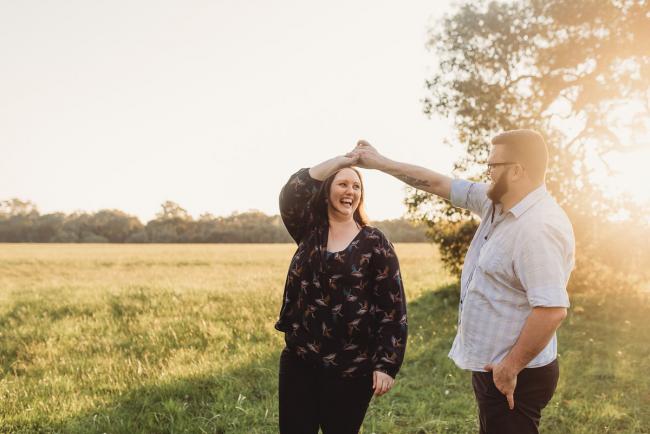 Man spinning woman around during Perth couples photography session at Perry's Paddock during golden hour
