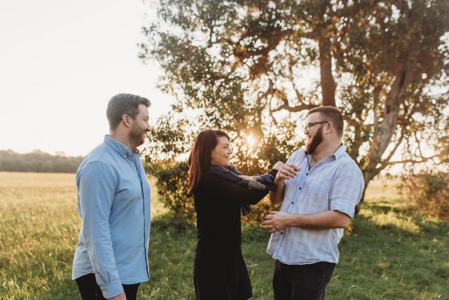 Older siblings laughing and tickling each other during Perth family photography session at Perry's Paddock during golden hour