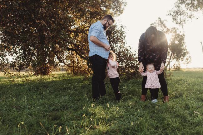Mother and father standing with daughters during Perth family photography session at Perry's Paddock during golden hour