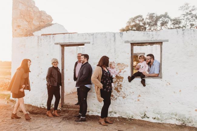 Family against a white building during Perth family photography session at Perry's Paddock during golden hour