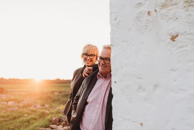 Man and woman leaning against white wall during Perth family photography session at Perry's Paddock during golden hour