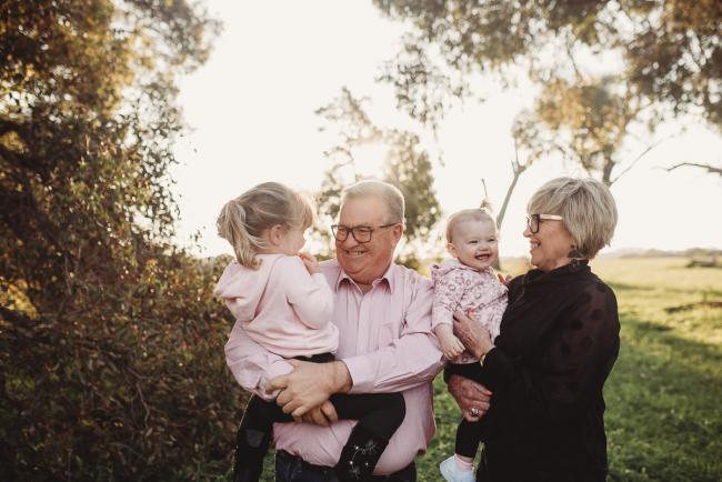 Grandparents holding granddaughters during Perth family photography session at Perry's Paddock during golden hour