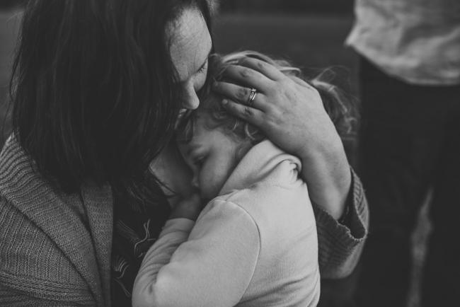 black and white image of mother cuddling daughter during Perth family photography session at Perry's Paddock during golden hour