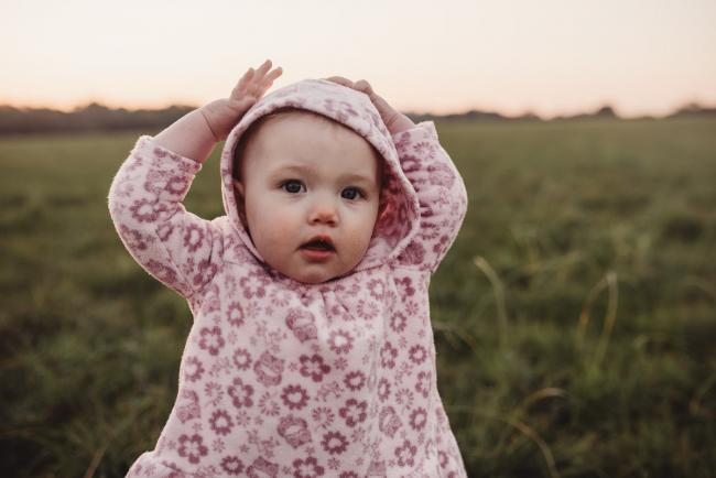 Little girl on grass during Perth family photography session at Perry's Paddock during golden hour