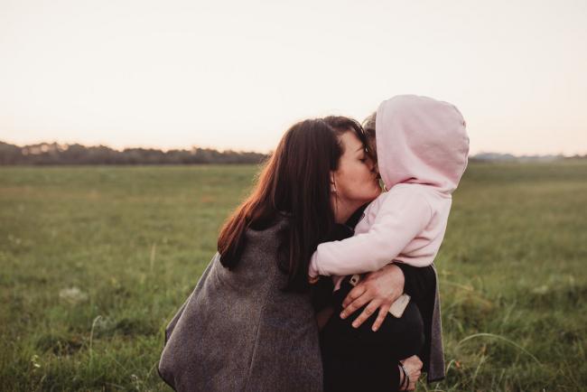 Woman kissing little girl during Perth family photography session at Perry's Paddock during golden hour
