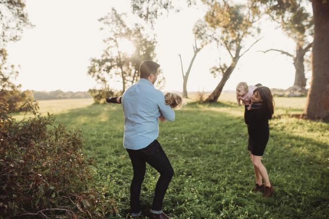 Aunty and uncle flying nieces around during Perth family photography session at Perry's Paddock during golden hour