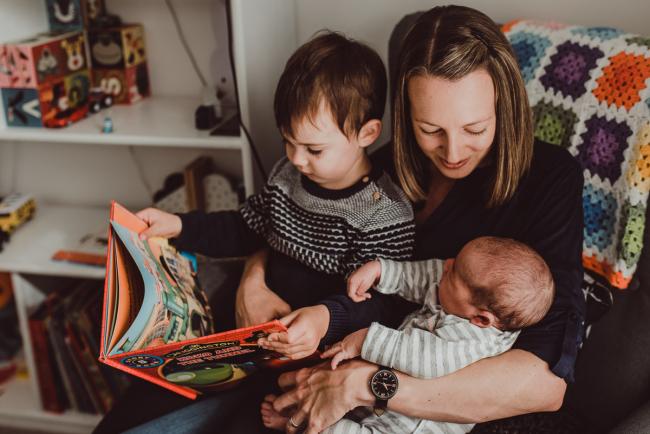 Mother holding two sons on her lap and reading with Lifestyle Newborn Photographer Perth