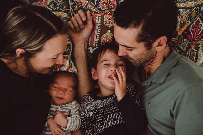 Family cuddling on the bed with Lifestyle Newborn Photographer Perth