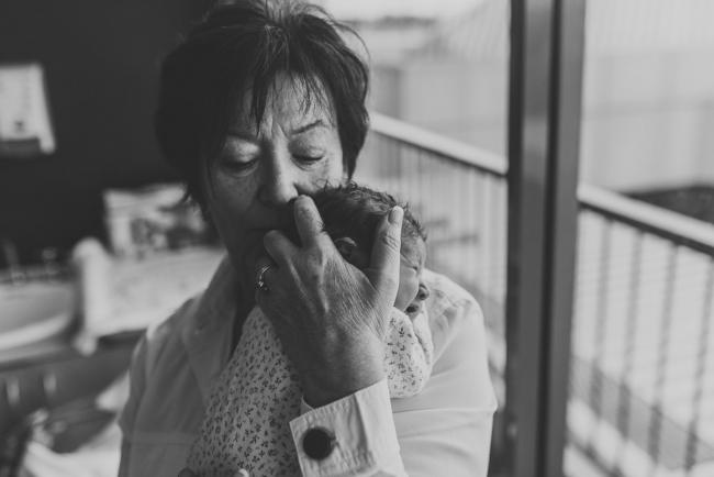 Black and white image of grandmother holding new baby granddaughter on her shoulder with Perth Fresh 48 Photographer at SJOG Mt Lawley