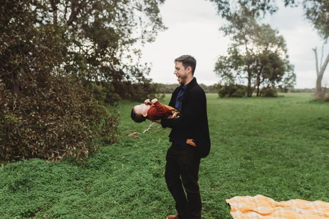 Father tipping daughter upside down with Perth family photographer at Perry's Paddock
