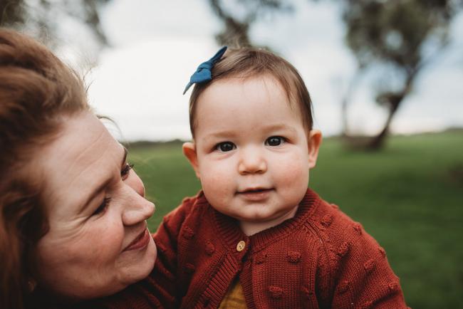 Mother smiling at daughter who is looking at the camera with Perth family photographer at Perry's Paddock