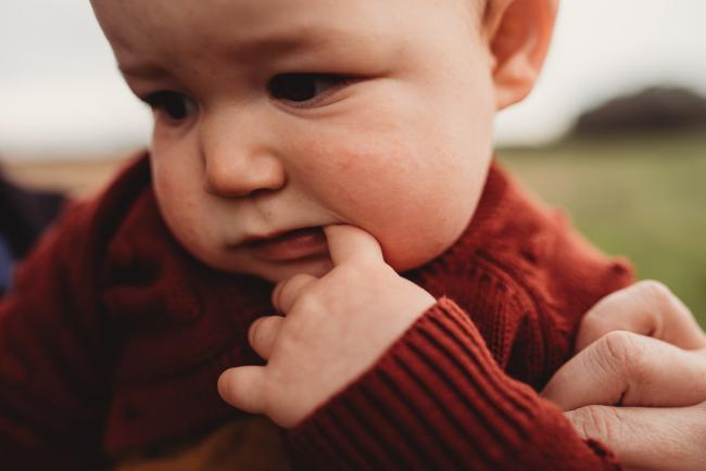 Close up of little girl with finger in her mouth with Perth family photographer at Perry's Paddock