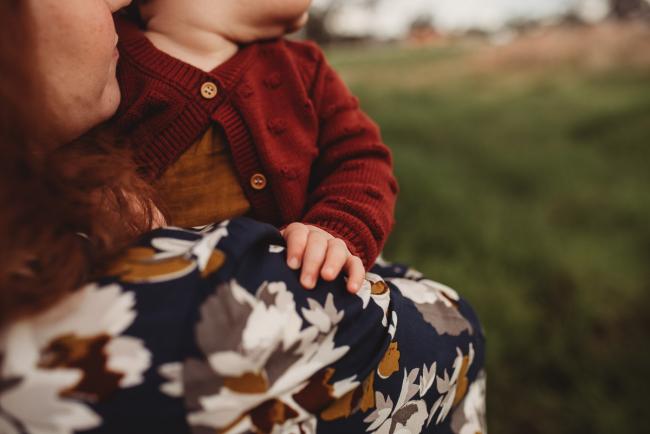 Little girl with hand on her mother's shoulder with Perth family photographer at Perry's Paddock