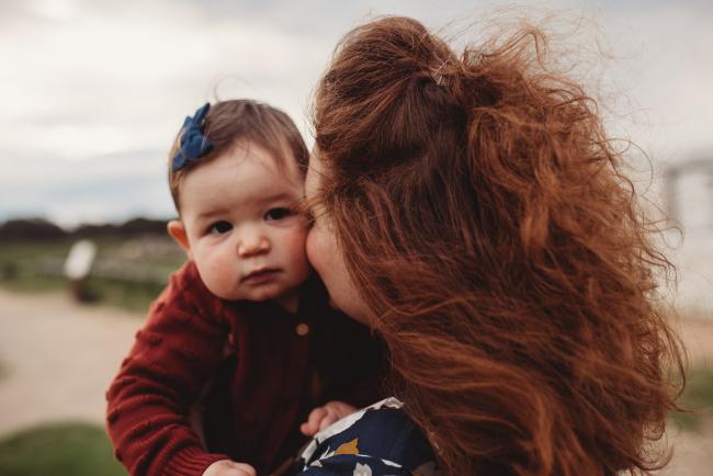 Mother kissing her daughter's cheek with Perth family photographer at Perry's Paddock