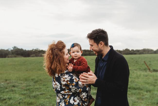 Parents with daughter who is clapping with Perth family photographer at Perry's Paddock