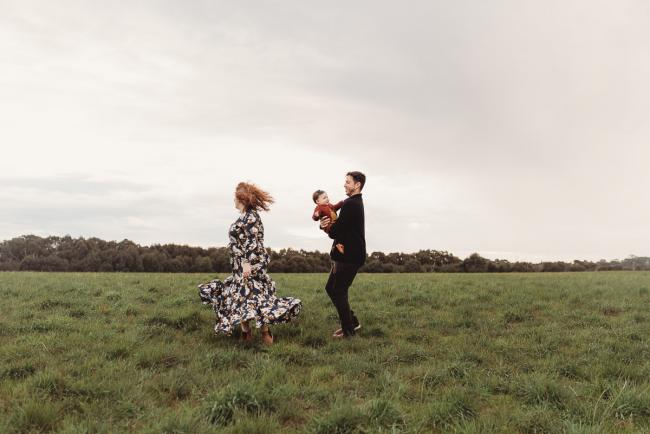 Father spinning with daughter as mother spins next to them with Perth family photographer at Perry's Paddock