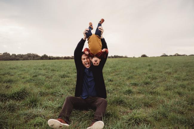 Father tipping daughter upside down with Perth family photographer at Perry's Paddock