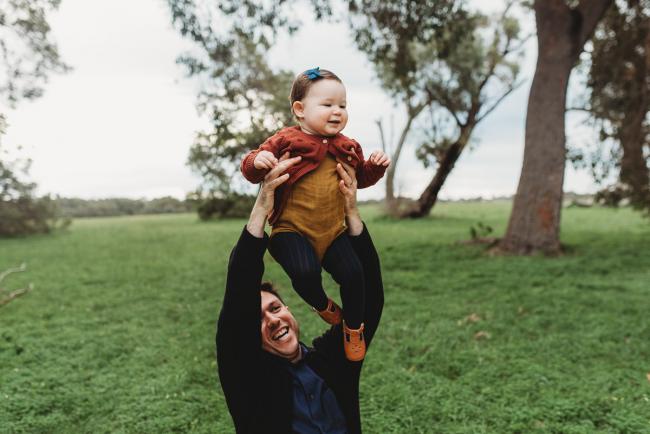 Father lifting daughter into the air with Perth family photographer at Perry's Paddock