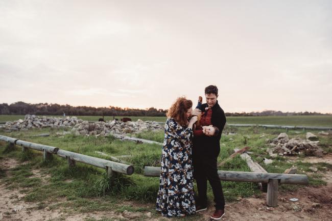 Father tipping daughter upside down as mother tickles her with Perth family photographer at Perry's Paddock