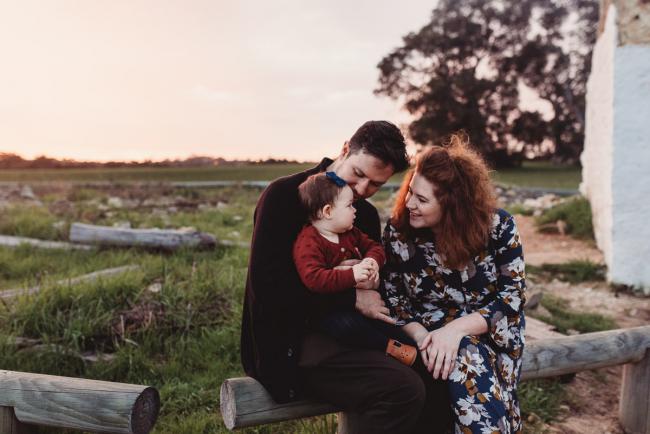 Parents sitting on a log with daughter with Perth family photographer at Perry's Paddock