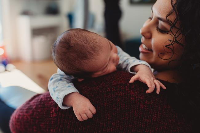 Baby over mother's shoulder with lifestyle newborn photographer Perth