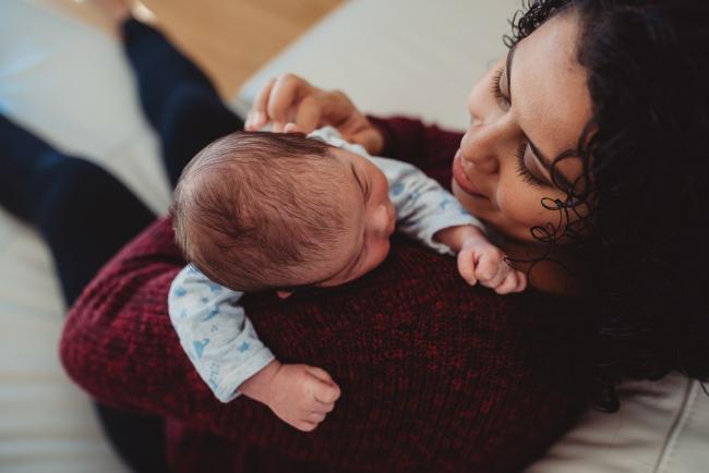 Baby on mother's shoulder with lifestyle newborn photographer Perth