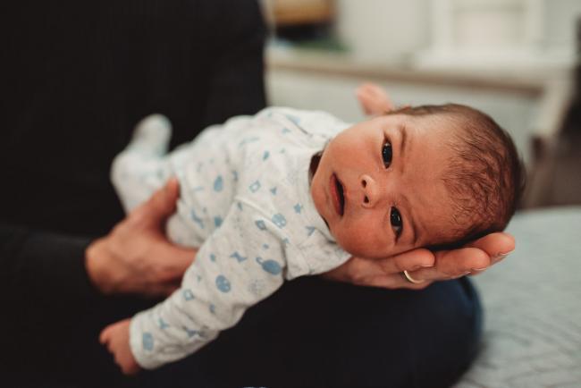 New baby on father's hand with lifestyle newborn photographer Perth