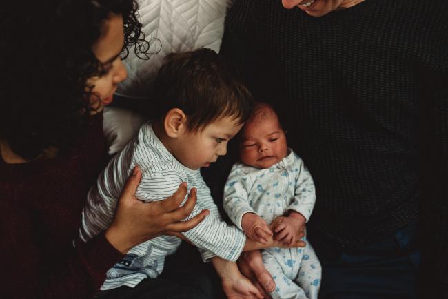 Little boy cuddling his baby brother with lifestyle newborn photographer Perth