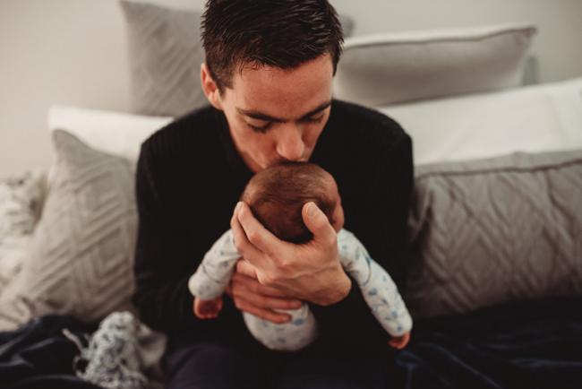 Father kissing baby with lifestyle newborn photographer Perth