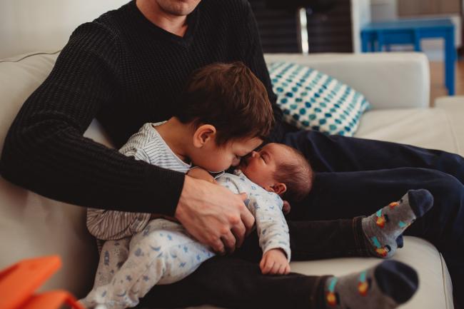 Little boy kissing baby brother with lifestyle newborn photographer Perth