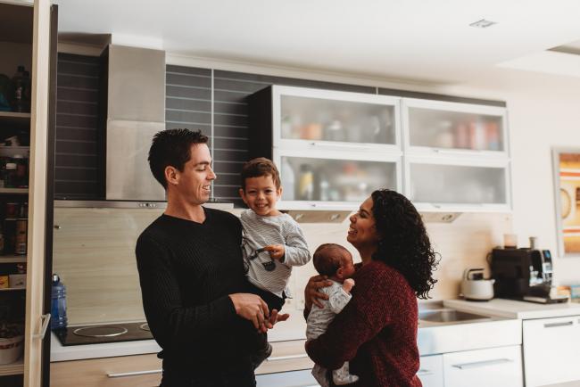 Family of four in the kitchen with lifestyle newborn photographer Perth