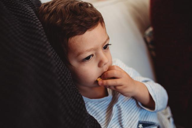Little boy with hands in his mouth with lifestyle newborn photographer Perth