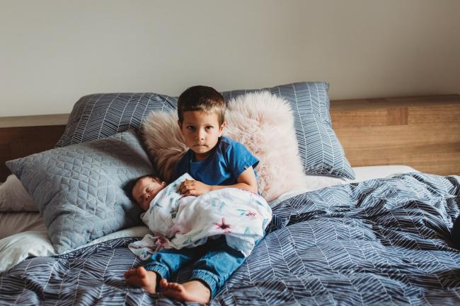 Perth-Newborn-Photographer-13-of-60 Little boy holding baby sister on the bed with Perth newborn lifestyle photographer