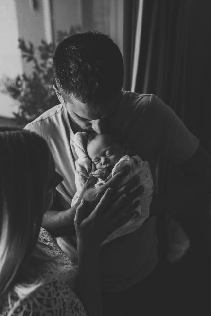 Perth-Newborn-Photographer-21-of-60 Black and white image of father holding newborn while mother leans in with Perth newborn lifestyle photographer