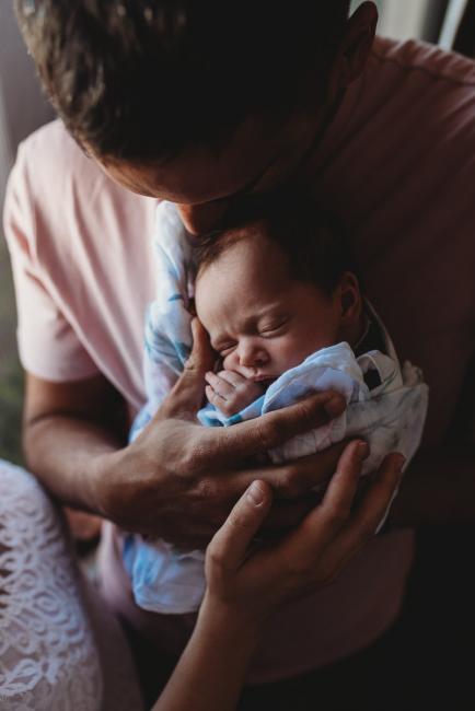 Perth-Newborn-Photographer-22-of-60 Newborn on dad's chest with parents hands on her with Perth newborn lifestyle photographer