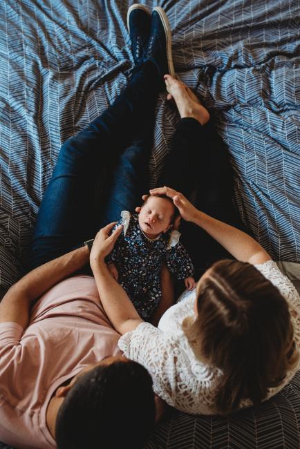 Perth-Newborn-Photographer-26-of-60 Top down image of newborn baby on parents laps with Perth newborn lifestyle photographer