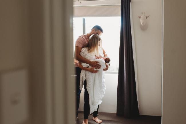 Perth-Newborn-Photographer-37-of-60-1 Parents standing with newborn baby by a window with Perth newborn lifestyle photographer
